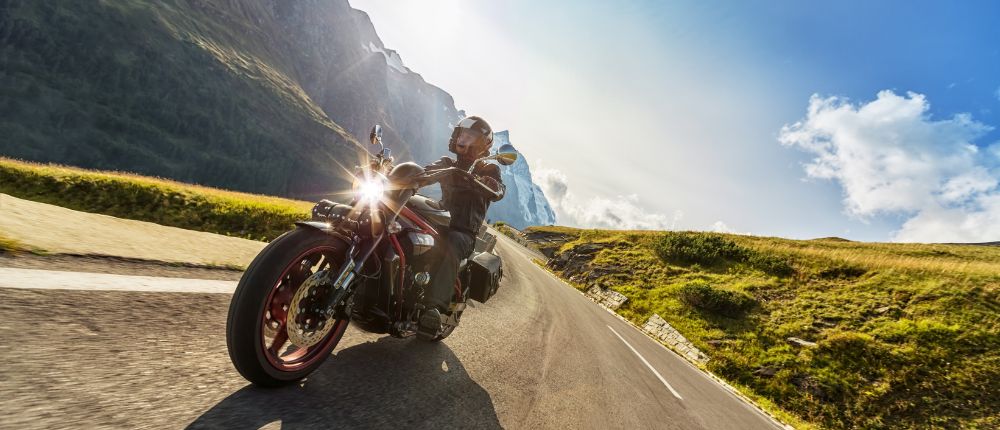 Motorradfahrer auf einer Passstraße in den Bergen.